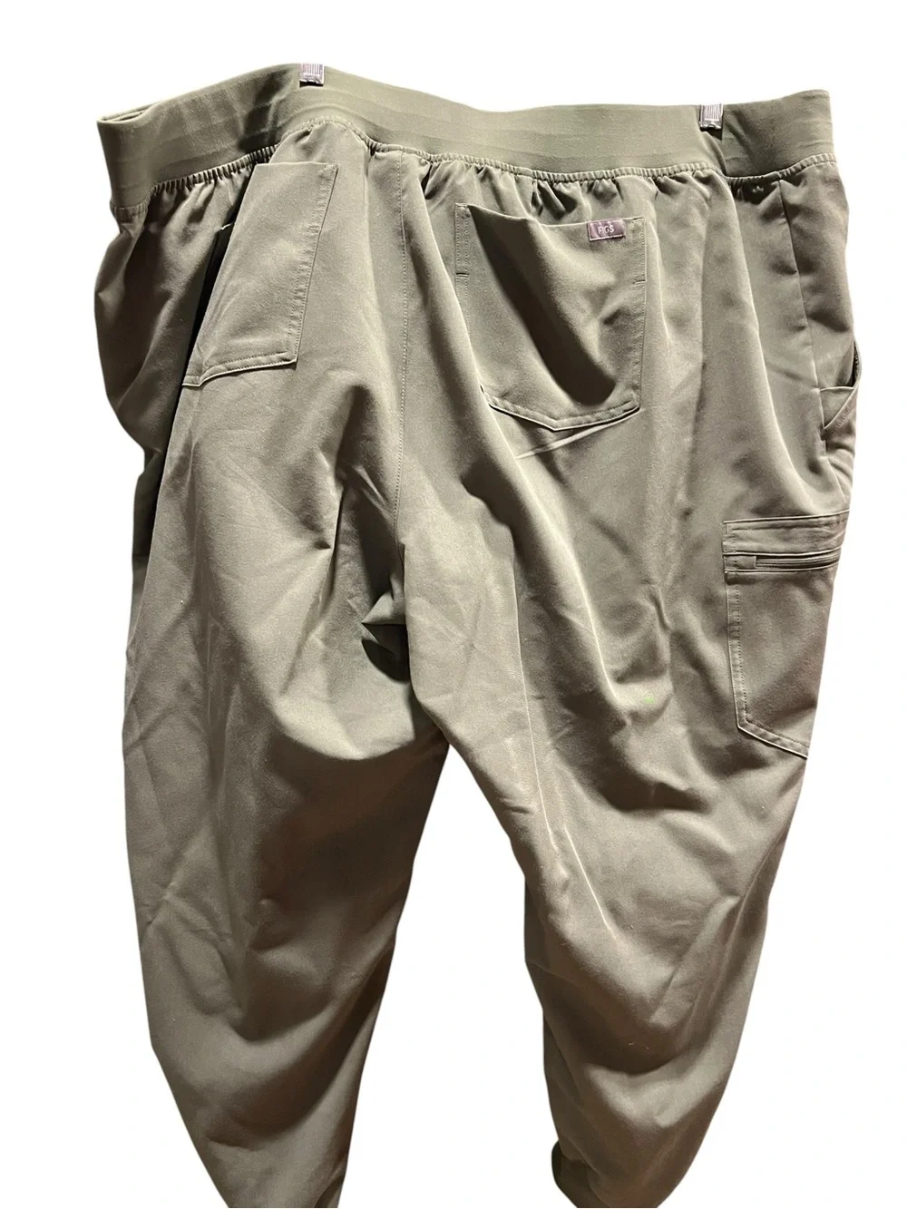 FIGS Casma three-pocket V-neck scrub top featuring a soft greyish-green.